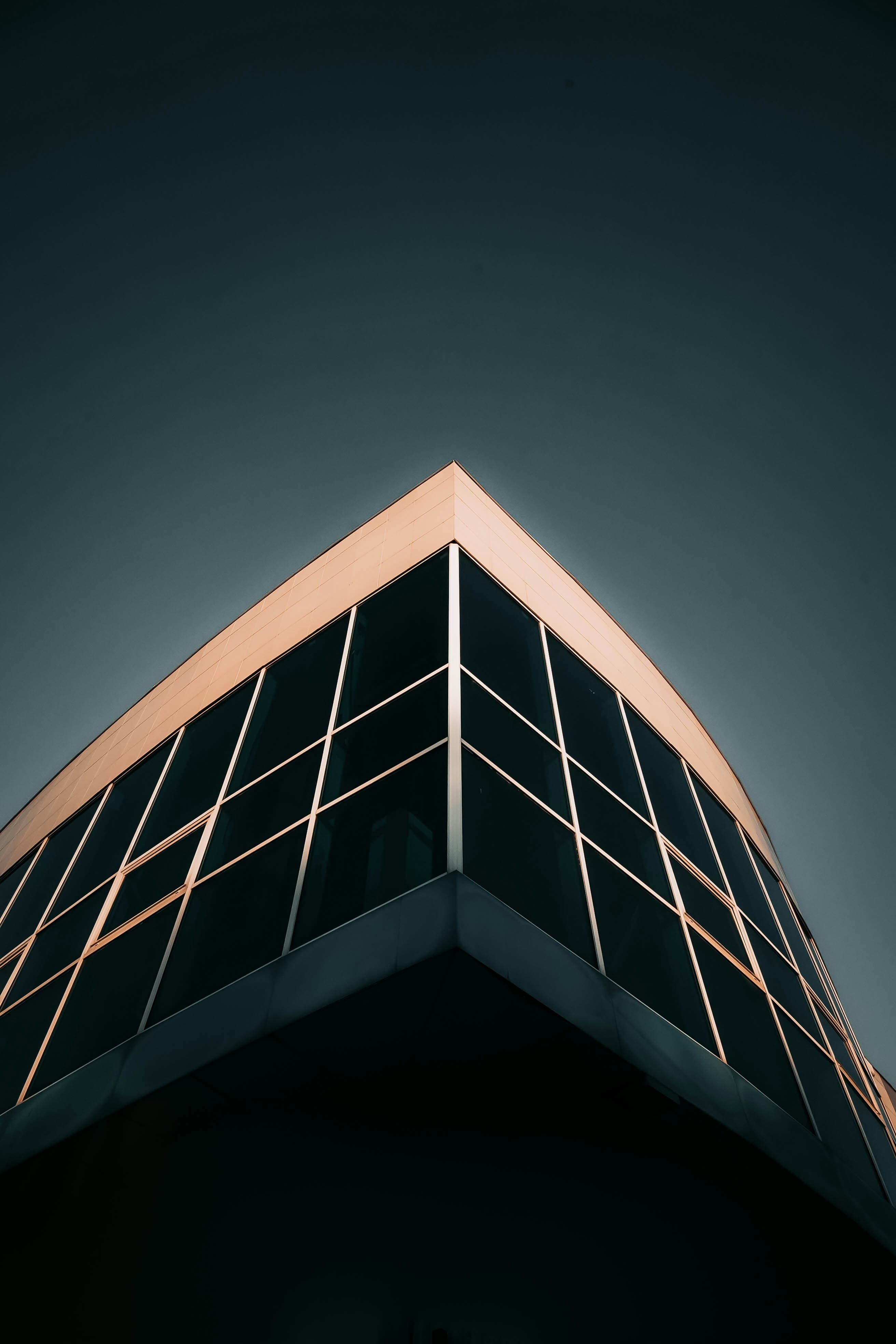 Angle d'un bâtiment contemporain, façade vitrée et rive en tôle cuivrée